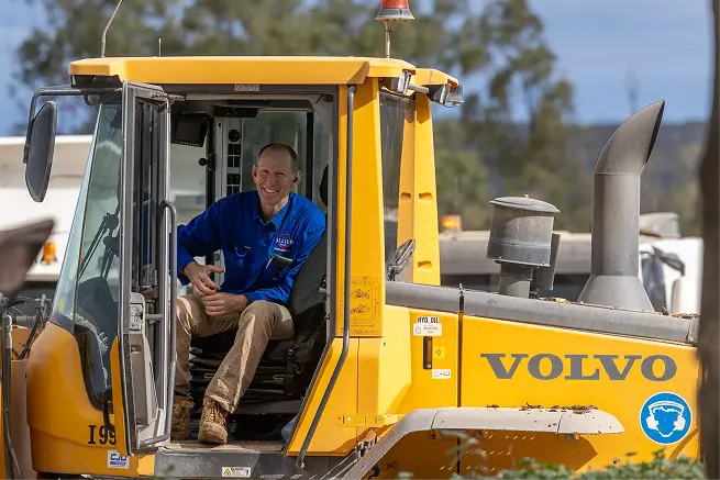 Allied Beef team member smiling from the cab of a yellow feed truck